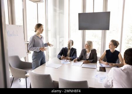 Young woman coach leads formal meeting in board room Stock Photo