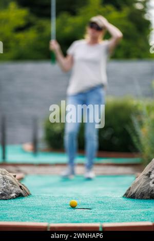 Woman missed shot during mini golf game. Summer fun sports and leisure activity Stock Photo