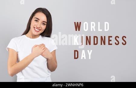 World Kindness Day. Grateful woman pressing hands to chest on grey background, banner design Stock Photo