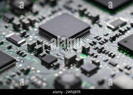 A close-up of a printed circuit board with a processor and various elements in backlight. Stock Photo