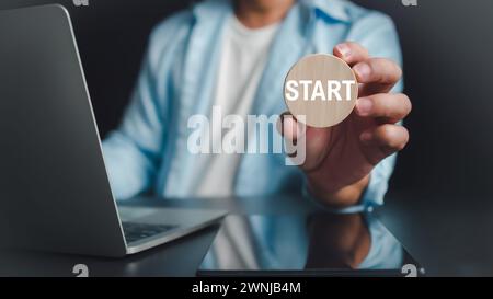 Businessman showing circle wooden and start lettering on desk with computer and tablet, Starting a new business, Planning to start a business, busines Stock Photo