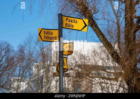 Vandalized fingerpost with directions to Pasila and Vallila in Heslperia Park, Helsinki, Finland Stock Photo