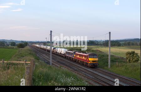 A DB Cargo freight train hauled by 2 class 90 electric locomotives carrying new Ford motor vehicles passes Plumpton on the west coast mainline Stock Photo