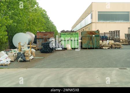 A significant amount of trash piled up in front of a building, creating a sight of environmental degradation and neglect. Stock Photo