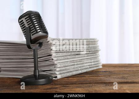 Newspapers and vintage microphone on wooden table. Journalist's work Stock Photo