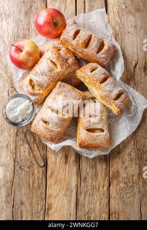 Homemade Puff pastry filled with apples close-up on a wooden table. Vertical top view from above Stock Photo