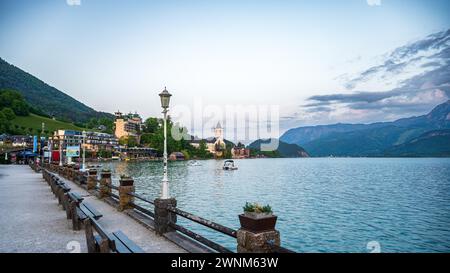View along a quiet lakeshore with benches and lanterns in a small town in the evening, Sankt Wolfgang, Wolfgangsee, Salzkammergut, Austria Stock Photo