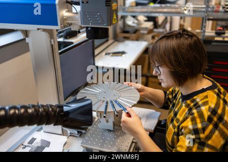 Woman operating a machine that prints logos on pens Stock Photo