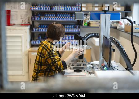 Woman operating a machine that prints logos on pens Stock Photo