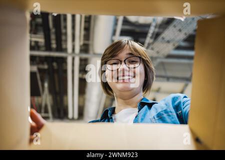 Warehouse female worker looking through an empty box Stock Photo