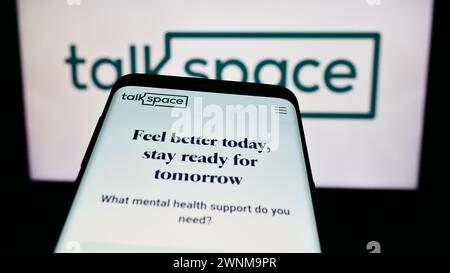 Mobile phone with website of US online psychotherapy company Talkspace Inc. in front of business logo. Focus on top-left of phone display. Stock Photo