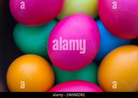 Easter eggs in brown bowl. Happy Easter holiday. Colourful painted eggs. Bright boiled eggs. Easter traditional decoration. Christian holiday. Stock Photo