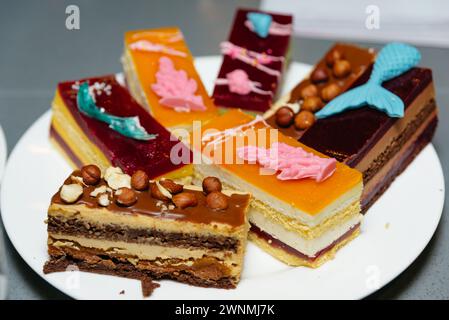 A selection of beautifully decorated cake slices on a plate, showcasing a variety of flavors and designs. Stock Photo