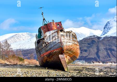 Corpach Fort William Scotland Old Boat of Caol the shipwreck on the beach with Ben Nevis mountain covered with snow Stock Photo