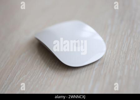 KYIV, UKRAINE - NOVEMBER 27, 2023 Apple Magic Mouse 3rd generation lies on wooden surface close up Stock Photo