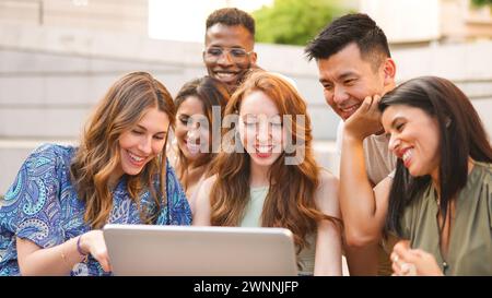 Friends using a laptop in the street Stock Photo