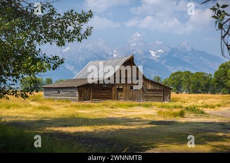 Peaks of the Grand Tetons rise up behind the T. A. Moulton Barn on Mormon Row in the Historic District of the Grand Teton National Park in Wyoming Stock Photo