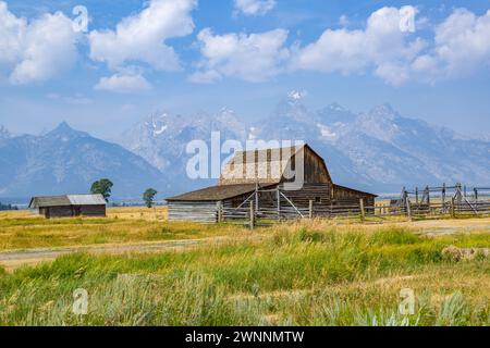 Peaks of the Grand Tetons rise up behind the John Moulton Barn on Mormon Row in the Historic District of the Grand Teton National Park in Wyoming Stock Photo