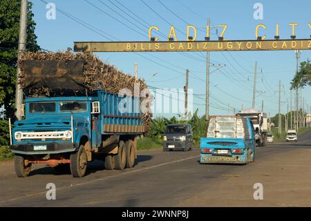 Overloaded trucks carrying sugarcane crop on road from Cadiz City to Bacolod, Negros Occidental, Philippines. Stock Photo