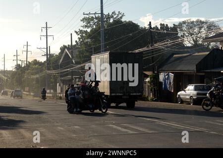 Overloaded trucks carrying sugarcane crop on road from Cadiz City to Bacolod, Negros Occidental, Philippines. Stock Photo