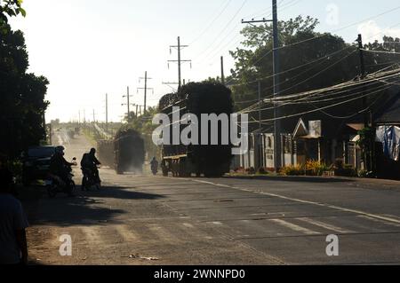 Overloaded trucks carrying sugarcane crop on road from Cadiz City to Bacolod, Negros Occidental, Philippines. Stock Photo