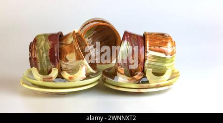 Empty cups made of multi-colored onyx in yellow-orange tones on a white background. Stock Photo
