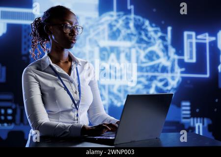 BIPOC woman developing artificial intelligence neural networks nodes modeled after human brain. Tech support setting up AI machine learning accurately making predictions using data Stock Photo