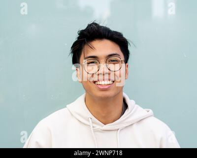 Portrait of a young teenager with glasses looking at camera smiling Stock Photo