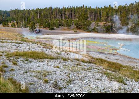 Run-off water from Excelsior Geyser Crater leaves brightly colored mineral deposits as it flows toward the Firehole River in the Midway Geyeser basin Stock Photo