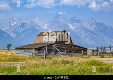 Peaks of the Grand Tetons rise up behind the John Moulton Barn on Mormon Row in the Historic District of the Grand Teton National Park in Wyoming Stock Photo