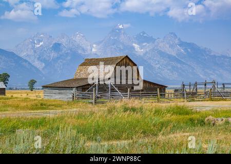 Peaks of the Grand Tetons rise up behind the John Moulton Barn on Mormon Row in the Historic District of the Grand Teton National Park in Wyoming Stock Photo