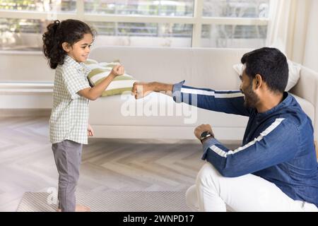 Positive strong Indian dad training little daughter kid Stock Photo