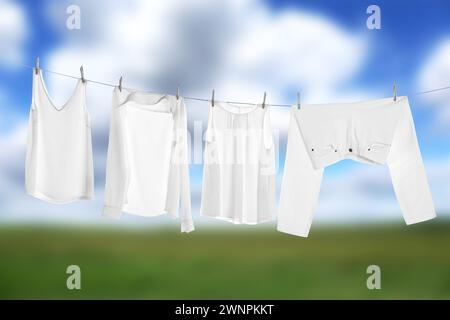 Different clothes drying on washing line outdoors Stock Photo