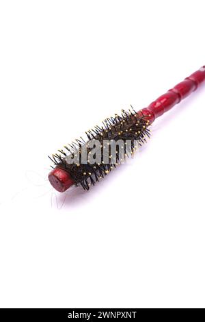 A dirty and tangled used red Colour Round Hair Brush comb or Hair curler and Massage roller isolated on white background. Stock Photo