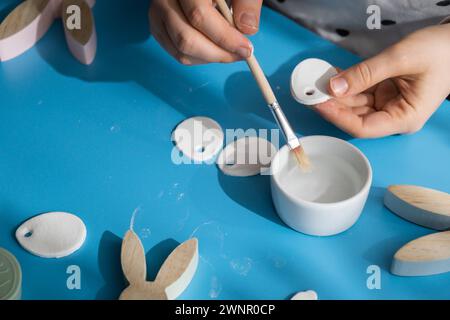 Creator is using white air dry clay for making decor to EASTER holiday. Creating hobby recreation activity that involves fingers. DIY crafting Modern art  Stock Photo