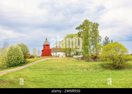 Idyllic church on a hill with a red bell tower in the Swedish countryside Stock Photo