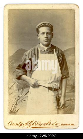Original Victorian Carte de Visite (visiting card or CDV) of young apprentice butcher lad wearing an apron and flat cap, with a tool belt holding a knife sharpner around his waist. From the studio of County of Gloucester studio, Cheltenham, U.K. circa 1880's Stock Photo