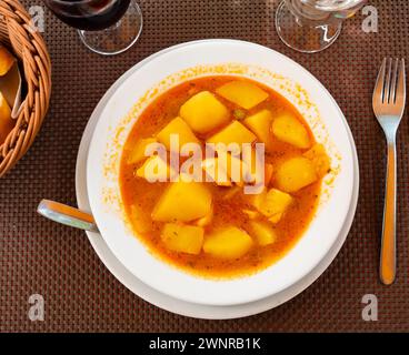 Stewed vegetables potatoes, carrots, onions in tomato sauce with cuttlefish Stock Photo