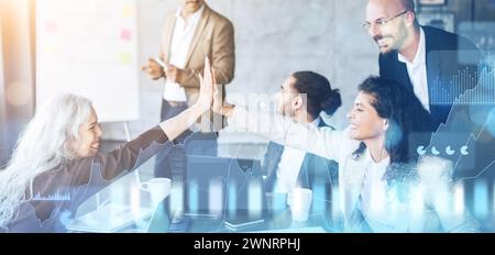 Energetic business team celebrating a success with a high-five in a collaborative office setting Stock Photo