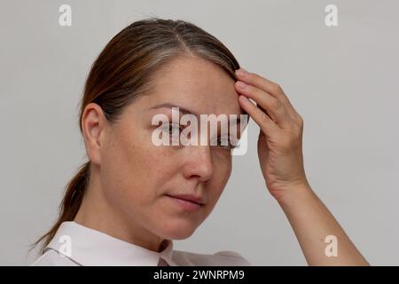 Portrait of caucasian middle aged beautiful woman of 40s with grey hair on white background Stock Photo