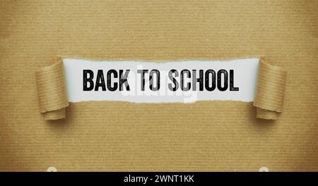 Torn paper revealing the words Back to school Stock Photo