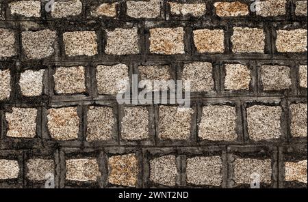 Stone wall textured background. Dark brown and beige bricks have textured and uneven shapes Stock Photo