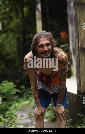 Man jumps from a cliff into the Alin-Alin waterfall. Bali Stock Photo