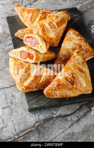 Sausage And Puff Pastry Turnovers closeup on the marble board on the table. Vertical Stock Photo