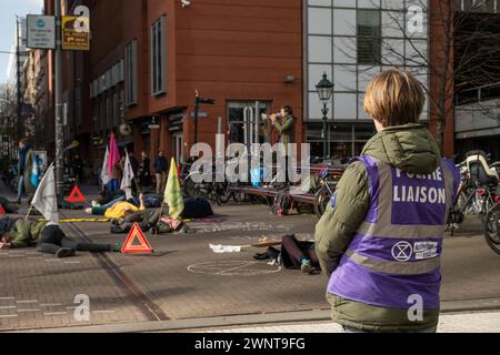 The Hague, Netherlands. 4th Mar 2024. Activists from direct action group Extinction Rebellion make peaceful protest for awareness of environmental climate change. Monthly air raid warning siren used as alarm and protesters die-in Credit: Drew McArthur/Alamy Live News Stock Photo