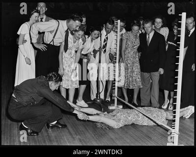 Sydney, Australia. February 1948 competion for Jitterbugs at Trocadero.  Male dancer slidding female partner under lower rung of bar Stock Photo