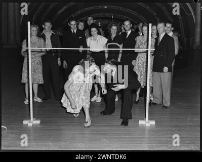 Sydney, Australia. February 1948 competion for Jitterbugs at Trocadero.  Male and Female dancer dancing under rung of bar Stock Photo