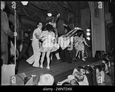 Sydney, Australia. February 1948 competion for Jitterbugs at Trocadero.  Couples on stage, while kids spectators watch Stock Photo