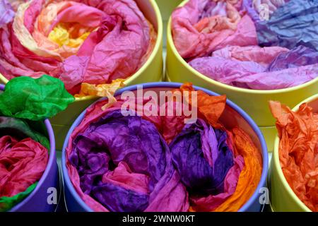 Bright colourful traditional silk shawls or scarves on a market counter, abstract multicolour background Stock Photo