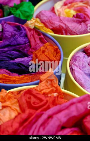 Bright colourful traditional silk shawls or scarves on a market counter, abstract multicolour background Stock Photo